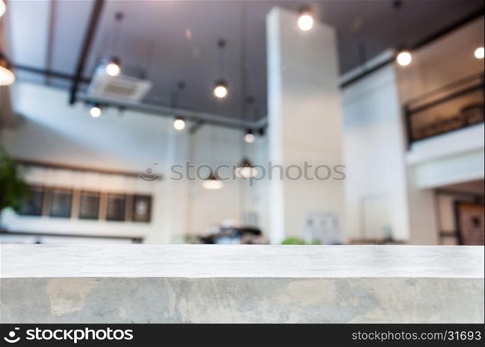 Concrete table top with abstract blur coffee shop interior for background