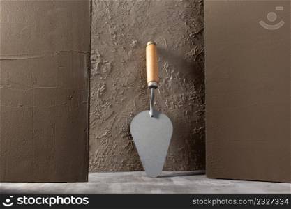 Concrete wall and construction trowel tool. Construction concept and mason