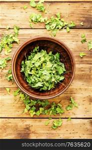 Condiment or spice made from dried green parsley.. Dried parsley flakes in bowl