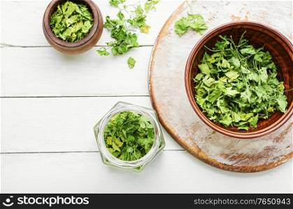 Condiment or spice made from dried green parsley.. Dried parsley on white background