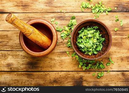 Condiment or spice made from dried parsley on wooden table. Dried parsley spice