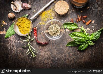 Condiments and spices for creative cooking on dark rustic wooden background, top view, banner