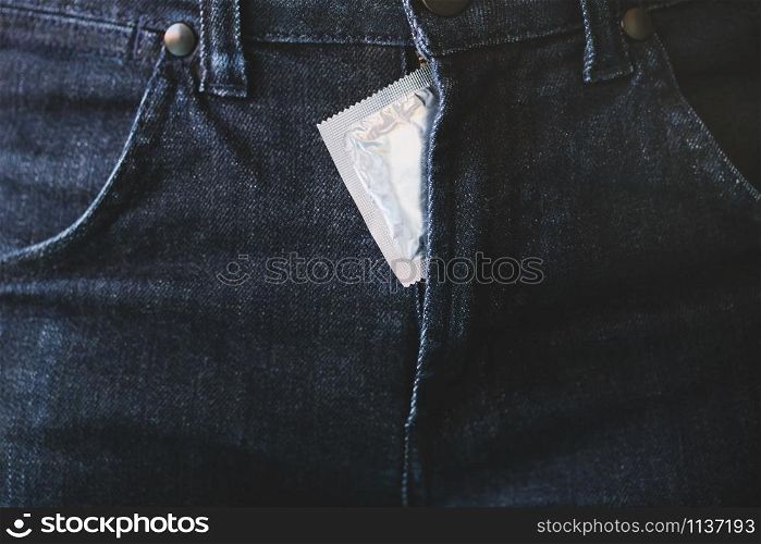 Condom man ready to use in pocket Jeans zipper pants, give condom safe sex concept on the bed Prevent infection and Contraceptives control the birth rate or safe prophylactic. World AIDS Day,