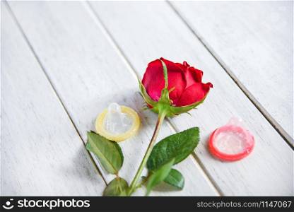 Condom Prevent Pregnancy Contraception Valentines safe sex concept / Birth Control with Condom and roses flower love on white wooden background - pregnancy or sexually transmitted disease