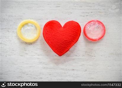 Condom Prevent Pregnancy Contraception Valentines safe sex concept / Birth Control with Condom and red heart love on white wooden background - pregnancy or sexually transmitted disease