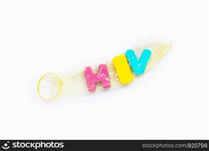 "Condom with "HIV" wooden alphabet on white background."