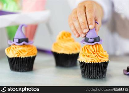 Confectioner decorate some cupcakes in the kitchen