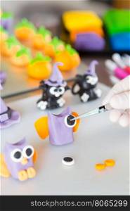 Confectioner working on the figures of Halloween with fondant paste