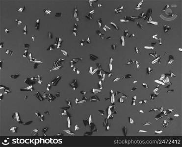 Confetti foil pieces on a black background. Abstract festive backdrop.. Confetti foil pieces on black background. Abstract festive backdrop.