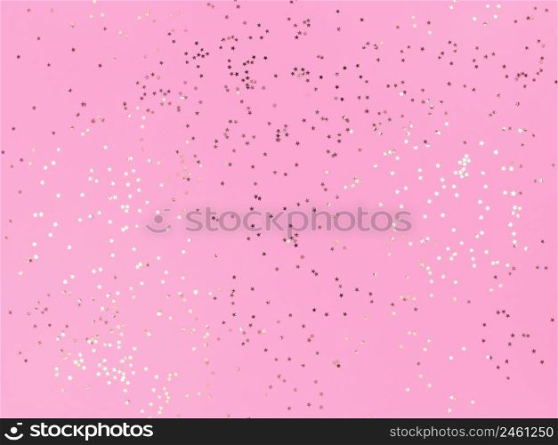 Confetti stars sparkling on pink background.. Confetti stars sparkling on a pink background.