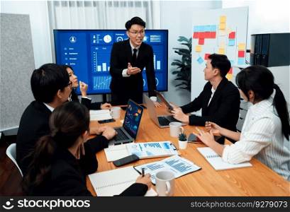 Confidence and asian busi≠ssman give presentation on financial analyzed by busi≠ss∫elli≥nce in dashboard report to other peop≤in board room meeting to promote harmony in workplace.. Confidence and young asian busi≠ssman give presentation to promote harmony.