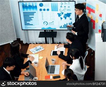 Confidence and asian businessman give presentation on financial analyzed by business intelligence in dashboard report to other people in board room meeting to promote harmony in workplace.. Confidence and young asian businessman give presentation to promote harmony.