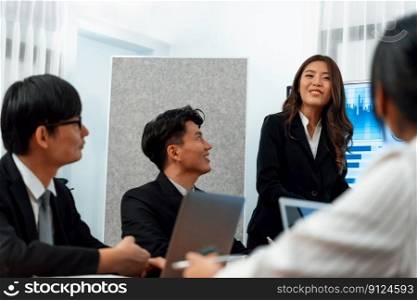 Confidence and young asian busi≠sswoman give presentation on financial busi≠ss strategy in dashboard report display on screen to col≤agues in conference room meeting as harmony in workplace concept. Busi≠sswoman give presentation on dashboard data on screen at harmony office.