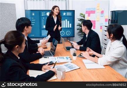 Confidence and young asian businesswoman give presentation on financial business strategy in dashboard report display on screen to colleagues in conference room meeting as harmony in workplace concept. Businesswoman give presentation on dashboard data on screen at harmony office.