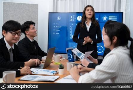 Confidence and young asian businesswoman give presentation on financial business strategy in dashboard report display on screen to colleagues in conference room meeting as harmony in workplace concept. Businesswoman give presentation on dashboard data on screen at harmony office.