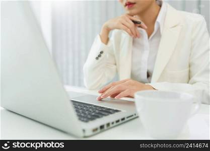 Confidence woman concept, Businesswoman is thinking strategy of business and typing data on laptop.