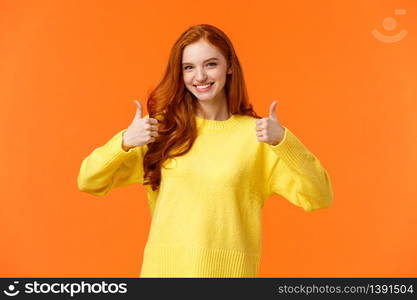 Confident and caring good-looking redhead sister rooting for sibling, saying yes, approving choice, recommend product, show thumbs-up and nod acceptance, smiling positive reply, orange wall.. Confident and caring good-looking redhead sister rooting for sibling, saying yes, approving choice, recommend product, show thumbs-up and nod acceptance, smiling positive reply, orange wall