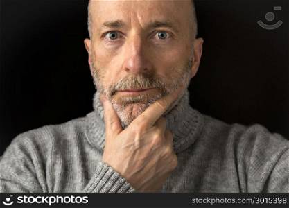 confident and positive 60 years old man with a beard - a headshot against a black background