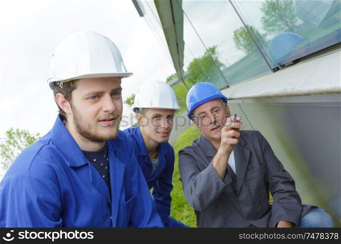 confident architect pointing at modern office building