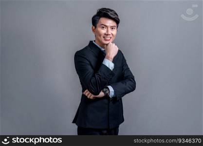 Confident Asian bossy businessman posing in professional formal black suit-clad on isolated background. Success corporate office worker for business promotion and advertisement. Jubilant. Confident Asian businessman posing on isolated background. Jubilant