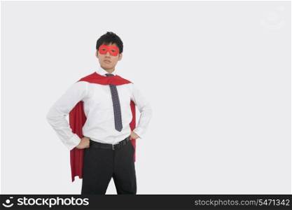 Confident Asian businessman in superhero costume