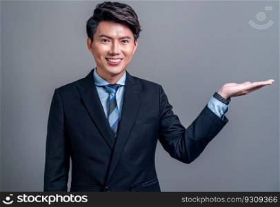 Confident Asian businessman posing in professional outfit on isolated background. Office worker pointing finger gesture for product sales promotions advertisements or HR recruitment image. Jubilant. Businessman make hand gesture for advertisements. Jubilant