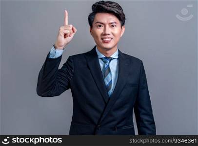 Confident Asian businessman posing in professional outfit on isolated background. Office worker pointing finger gesture for product sales promotions advertisements or HR recruitment image. Jubilant. Businessman make hand gesture for advertisements. Jubilant