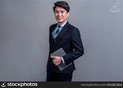 Confident Asian businessman posing with tablet on isolated background. Office worker make hand holding gesture for promotions sales or technology and innovation products advertisements. Jubilant. Businessman make hand holding gesture for advertisements with tablet. Jubilant