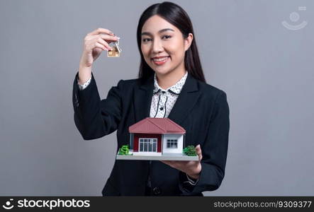 Confident Asian businesswoman holding house model, advertising home loan with smile. Real estate agent with sample house model in hand on isolated background for business advertisements. Jubilant. Confident Asian businesswoman holding house model. Jubilant