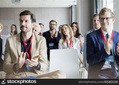 Confident business people applauding during seminar