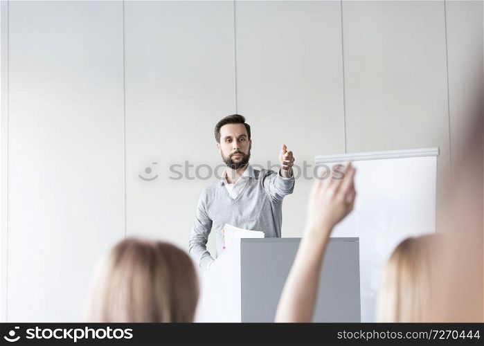 Confident businessman answering question to colleagues in conference