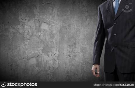 Confident businessman. Chest view of businessman against cement wall