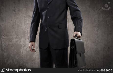 Confident businessman. Close up of businessman body in suit against cement background