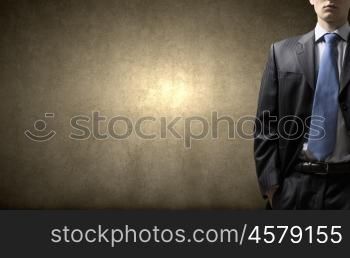 Confident businessman. Close up of businessman with hands in pockets