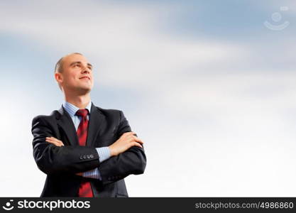 Confident businessman. Image of young confident businessman holding arms crossed