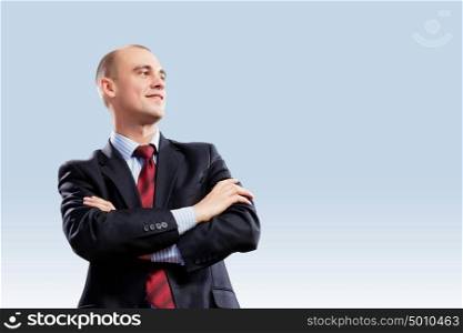 Confident businessman. Image of young confident businessman holding arms crossed