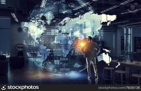 Confident businessman in night office and media interface with world map. Mixed media. His strategy of global business