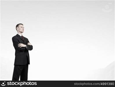 Confident businessman . Serious young businessman with arms crossed on chest
