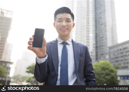 Confident businessman showing a phone
