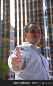 Confident businessman showing thumbs up, focus on a hand