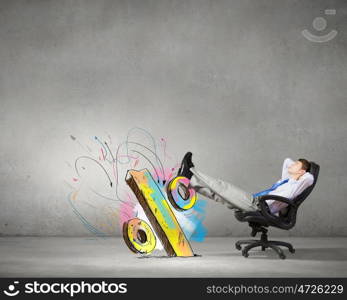 Confident businessman sitting on chair with legs up. Relaxed businessman