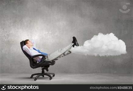 Confident businessman sitting on chair with legs up. Relaxed businessman