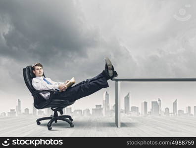 Confident businessman. Smiling businessman sitting in chair with legs on table