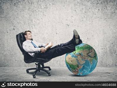 Confident businessman. Young handsome businessman sitting in chair with book in hands. Elements of this image are furnished by NASA