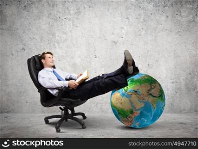 Confident businessman. Young handsome businessman sitting in chair with book in hands. Elements of this image are furnished by NASA