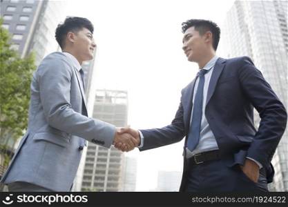 Confident businessmen shaking hands