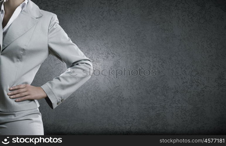 Confident businesswoman. Chest view of businesswoman in suit against cement wall