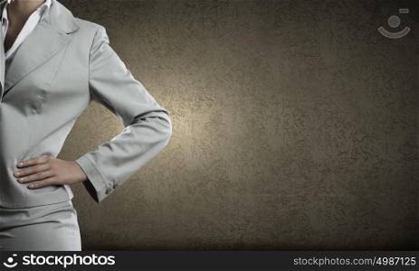 Confident businesswoman. Chest view of businesswoman in suit against cement wall