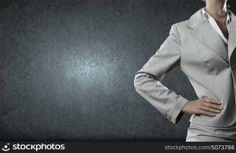 Confident businesswoman. Chest view of businesswoman in suit against cement wall