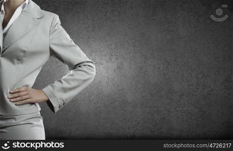 Confident businesswoman. Chest view of businesswoman standing against cement wall